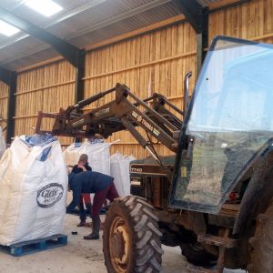 Hempen barn, moving hemp seeds with the tractor into the barn to be stored